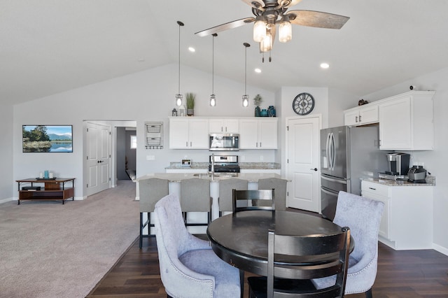 carpeted dining room with high vaulted ceiling, ceiling fan, and sink