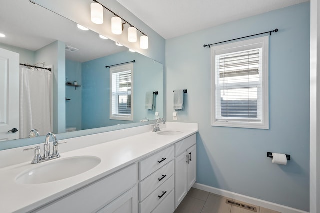 bathroom featuring toilet, vanity, and tile patterned floors