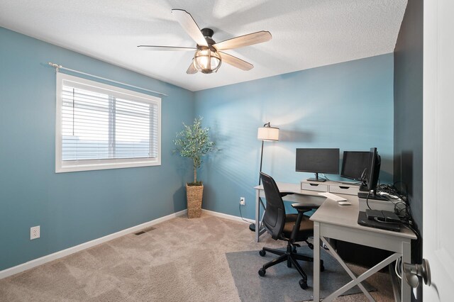 carpeted office with ceiling fan and a textured ceiling