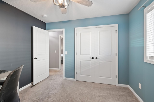 carpeted home office featuring ceiling fan, plenty of natural light, and a textured ceiling