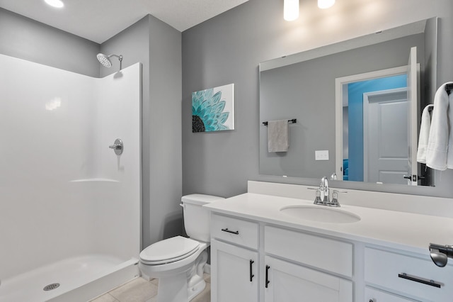 bathroom with a shower, tile patterned flooring, vanity, and toilet