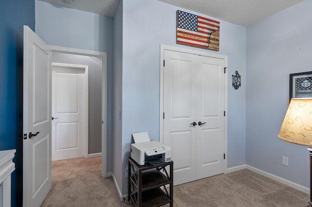 carpeted foyer featuring a textured ceiling