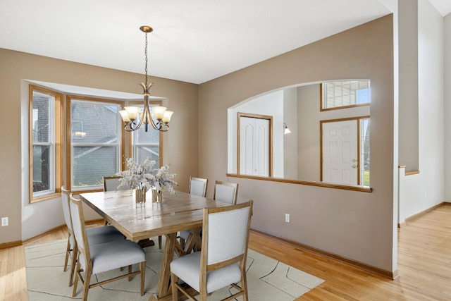 dining space with a notable chandelier and light wood-type flooring