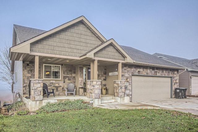 craftsman inspired home with a porch, a garage, and a front lawn