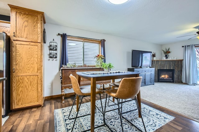 dining room featuring a textured ceiling, dark hardwood / wood-style flooring, and ceiling fan