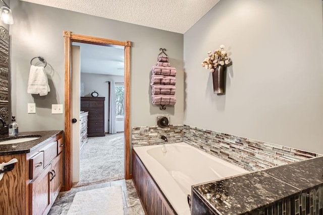 bathroom featuring a bathtub, vanity, and a textured ceiling