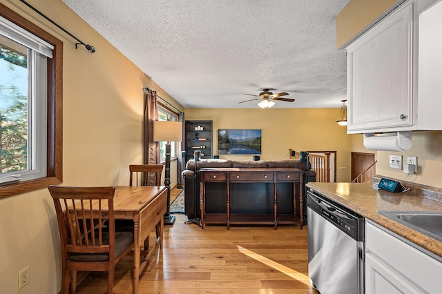 kitchen featuring white cabinets, a textured ceiling, light wood-type flooring, and dishwasher