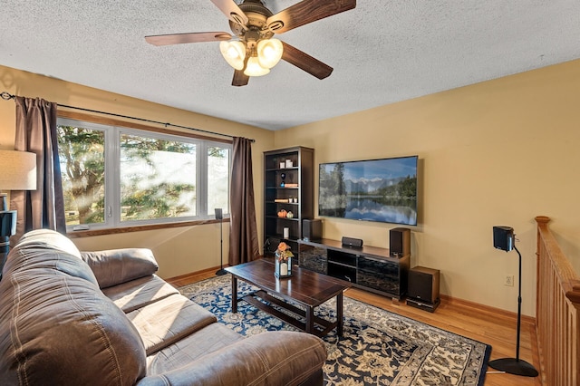 living room with hardwood / wood-style floors, ceiling fan, and a textured ceiling