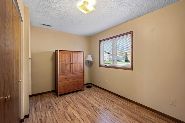 bedroom featuring light wood-type flooring and a textured ceiling