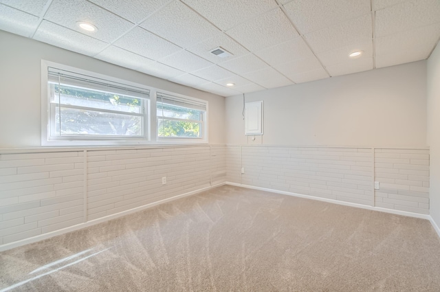 carpeted spare room featuring a paneled ceiling