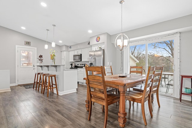 dining area featuring lofted ceiling, dark wood-type flooring, and a notable chandelier