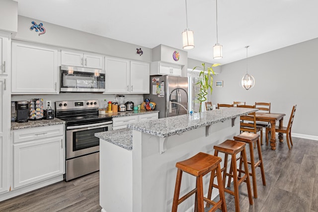 kitchen featuring a kitchen island with sink, white cabinets, dark hardwood / wood-style floors, and appliances with stainless steel finishes