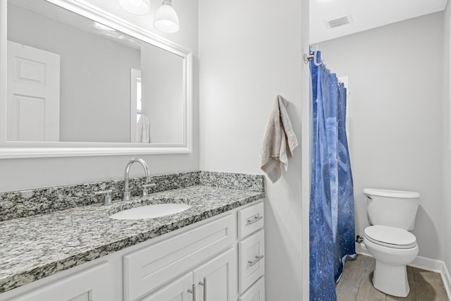 bathroom with wood-type flooring, vanity, and toilet