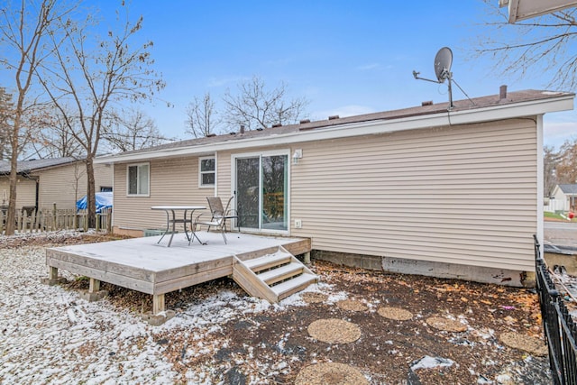 snow covered back of property featuring a wooden deck