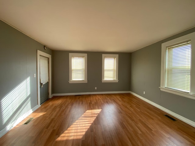 empty room with wood-type flooring and plenty of natural light