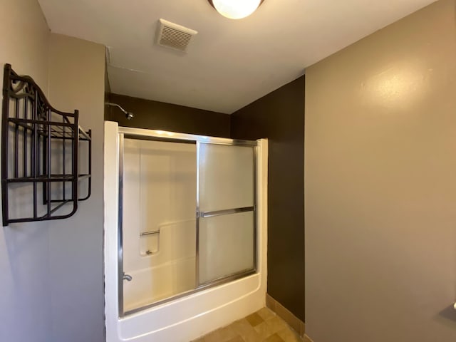 bathroom with combined bath / shower with glass door