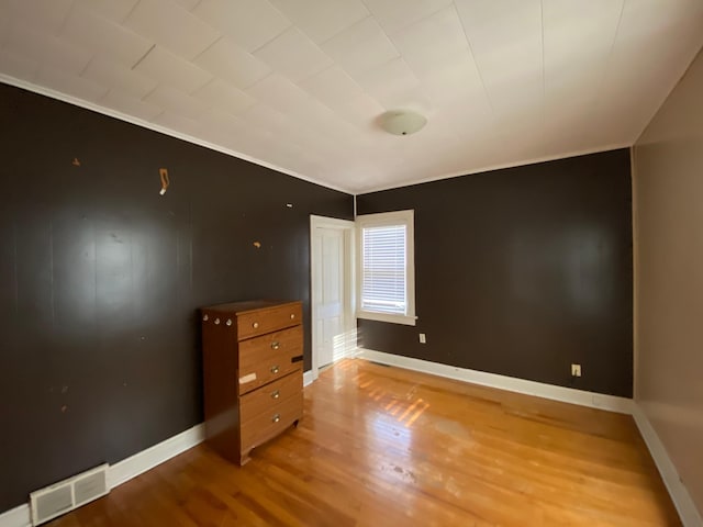 unfurnished bedroom featuring ornamental molding and hardwood / wood-style flooring