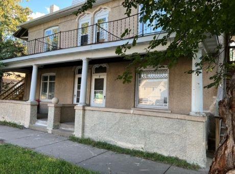 217 Spring St, Mankato, MN 56001 - view of front of house with a balcony, covered porch, and stucco siding