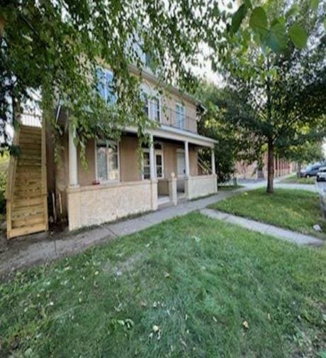 217 Spring St, Mankato, MN 56001 - view of front of property featuring stairway, a front yard, and stucco siding