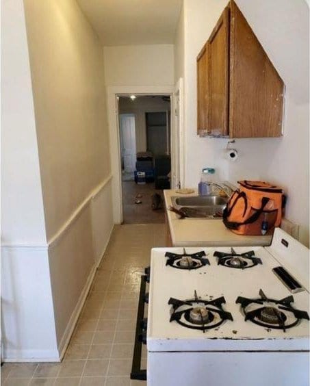 217 Spring St, Mankato, MN 56001 - kitchen featuring white gas stove, light countertops, and brown cabinetry
