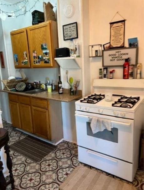 217 Spring St, Mankato, MN 56001 - kitchen featuring white range with gas cooktop and brown cabinetry