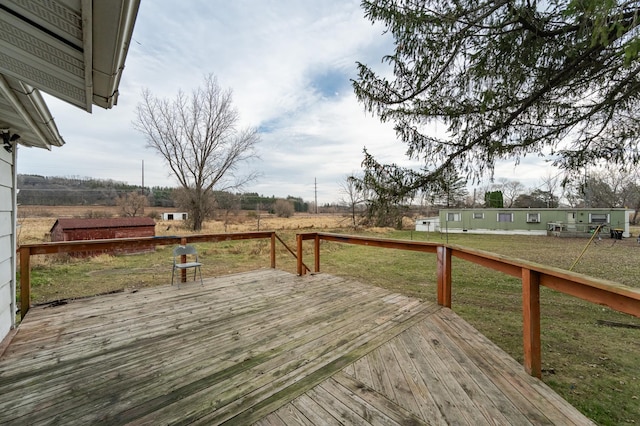 wooden deck featuring a yard and a rural view