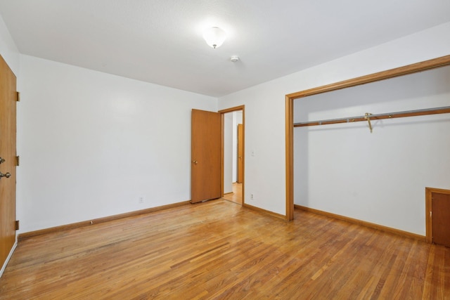 unfurnished bedroom featuring light hardwood / wood-style flooring and a closet