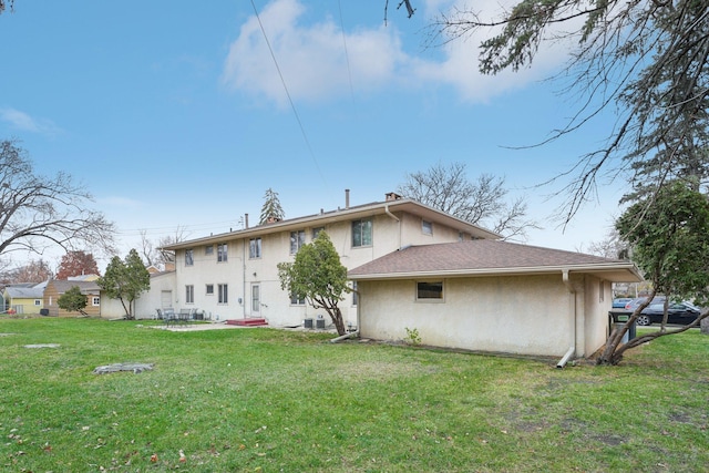 back of property featuring a lawn