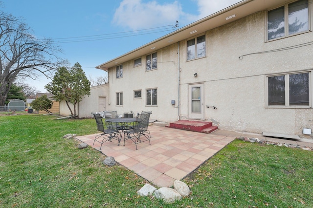 rear view of property with a yard and a patio