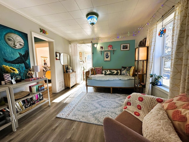 bedroom with wood-type flooring and ornamental molding