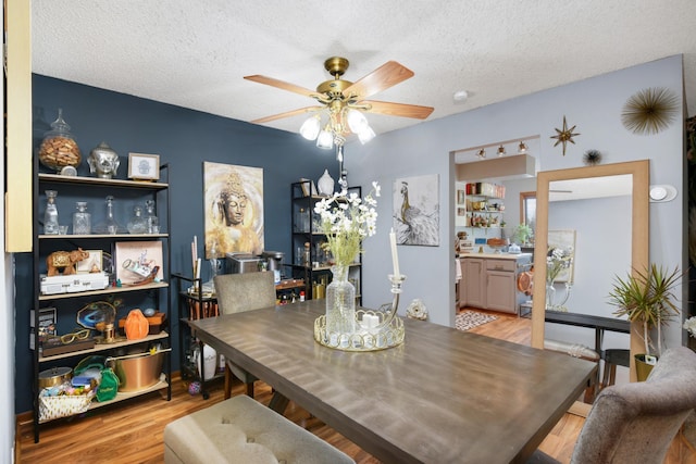 dining room with light hardwood / wood-style flooring, a textured ceiling, and ceiling fan