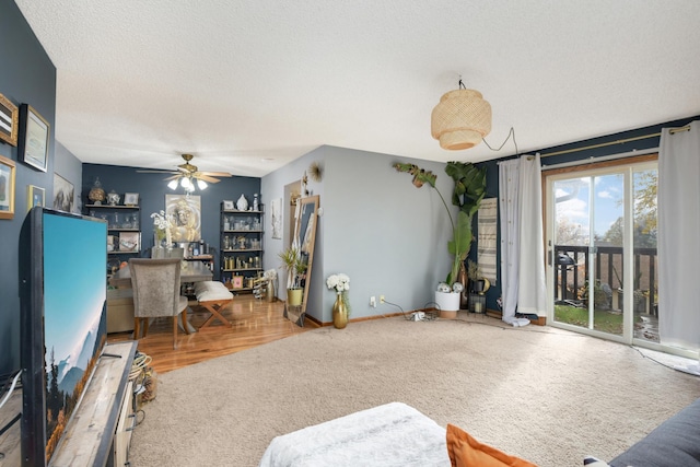 living room with a textured ceiling, hardwood / wood-style flooring, and ceiling fan