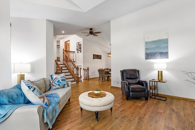 living room with hardwood / wood-style flooring, vaulted ceiling, and ceiling fan