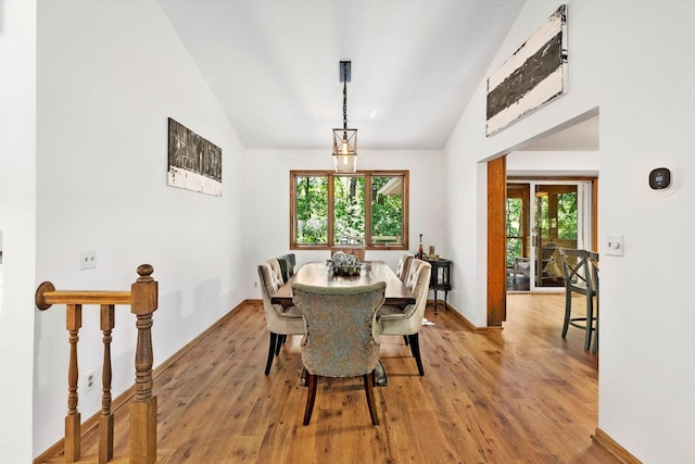 dining space featuring a healthy amount of sunlight, high vaulted ceiling, and light hardwood / wood-style flooring