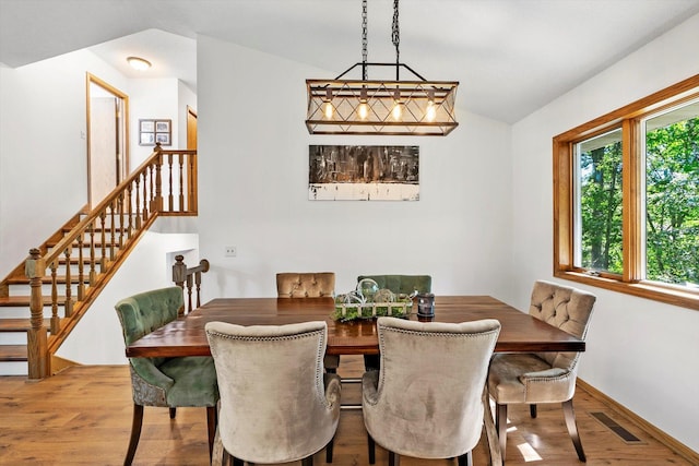 dining area with hardwood / wood-style floors and vaulted ceiling