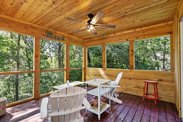 sunroom featuring ceiling fan, plenty of natural light, and wood ceiling