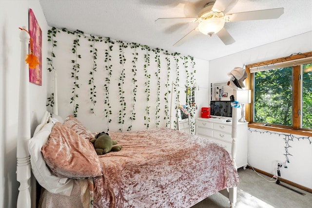 bedroom with a textured ceiling, carpet floors, and ceiling fan