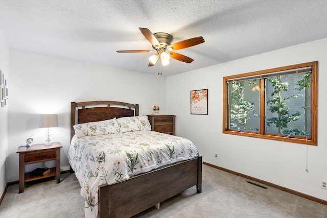 carpeted bedroom featuring a textured ceiling and ceiling fan