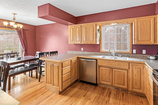 kitchen with sink, appliances with stainless steel finishes, an inviting chandelier, hanging light fixtures, and light wood-type flooring