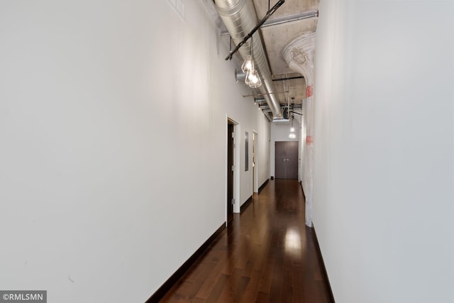 corridor featuring dark hardwood / wood-style flooring and a high ceiling