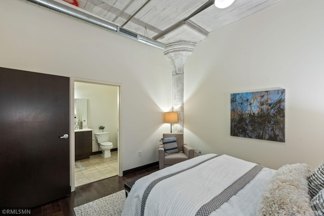 bedroom featuring hardwood / wood-style flooring and ensuite bathroom