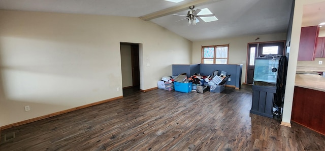 interior space featuring lofted ceiling with skylight, dark hardwood / wood-style flooring, and ceiling fan