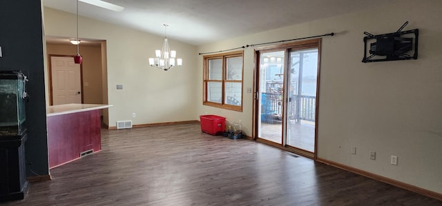 interior space with dark hardwood / wood-style flooring, an inviting chandelier, and vaulted ceiling