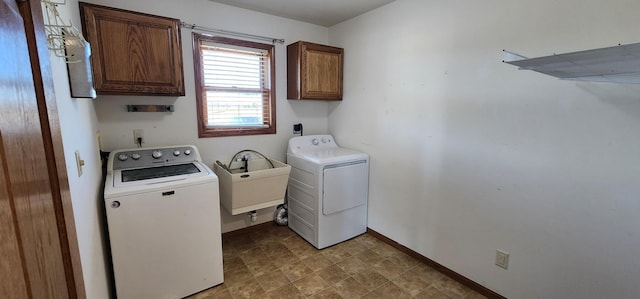 washroom featuring washer and dryer, cabinets, and sink