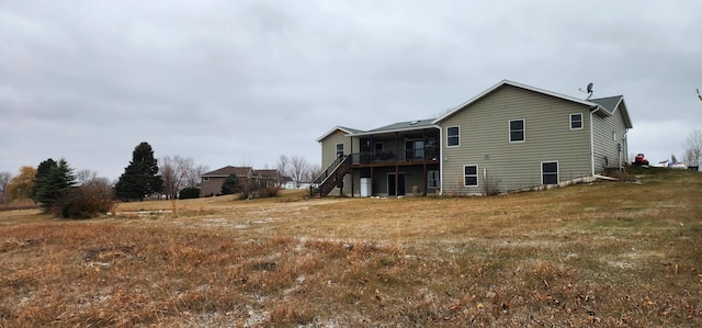 back of house with a deck and a lawn