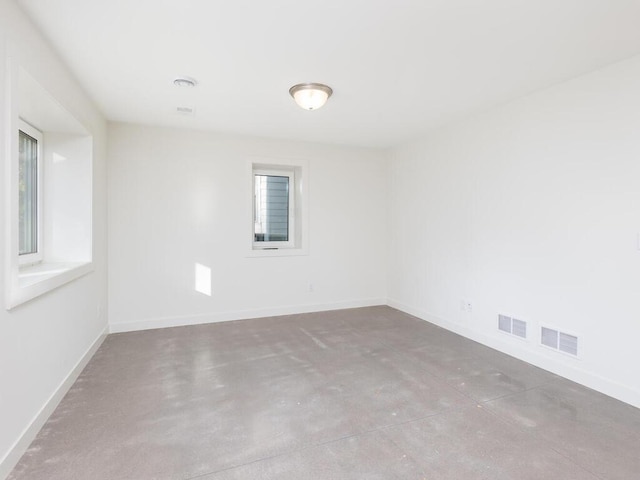 unfurnished room featuring a wealth of natural light and concrete floors