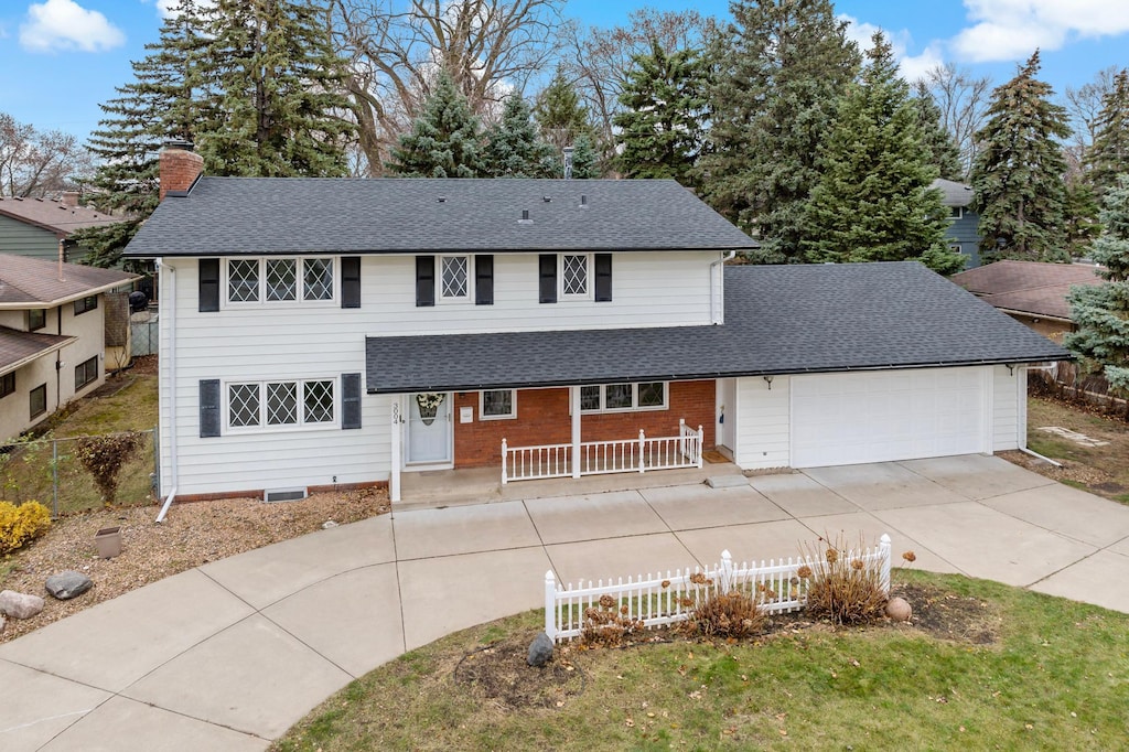 front facade featuring covered porch and a garage