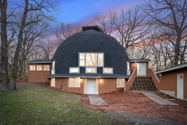 back house at dusk with a yard