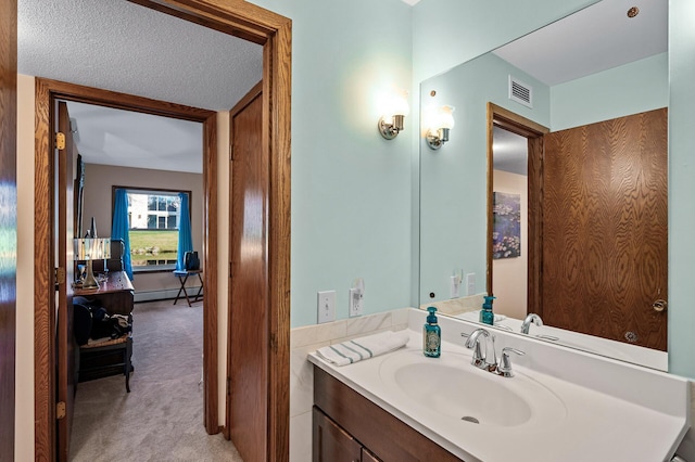 bathroom featuring a baseboard radiator, vanity, and a textured ceiling