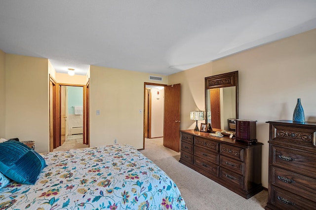 bedroom featuring light colored carpet and connected bathroom